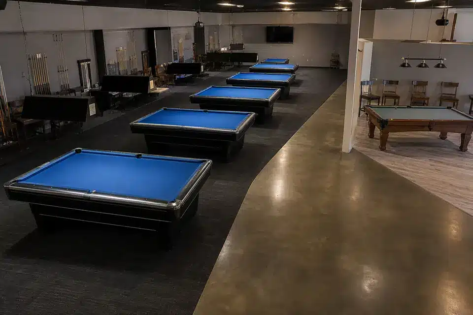 Empty mid-range billiard club layout with matching pool tables and a secondary table area